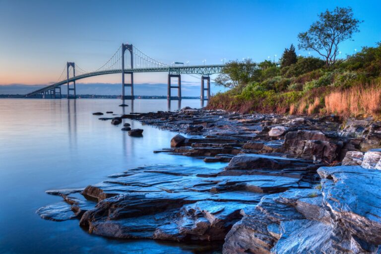 A body of water with rocks and trees in the foreground.