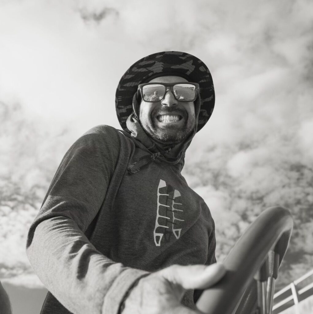 A man in a helmet and glasses is smiling.