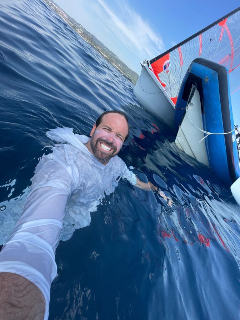 A man in the water with his arms around him.