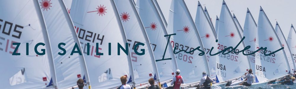 A group of people in sailboats on the water.